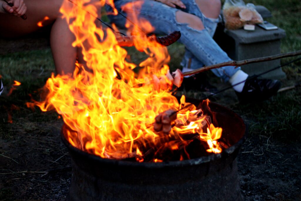 Eldplats där två personer grillar ute i naturen